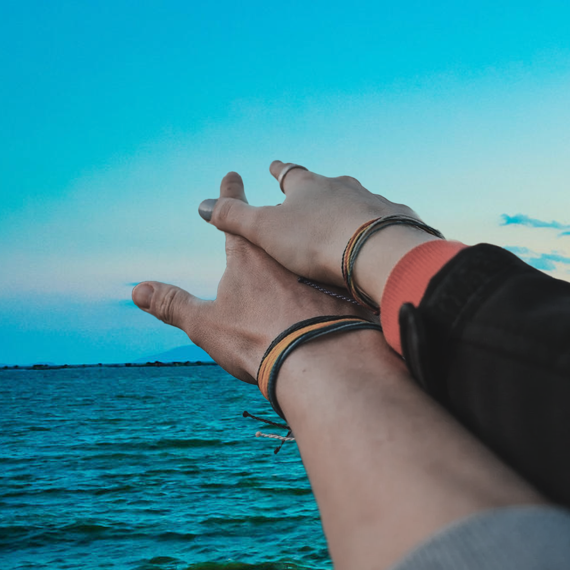 a photo of two hands pointing out to sea