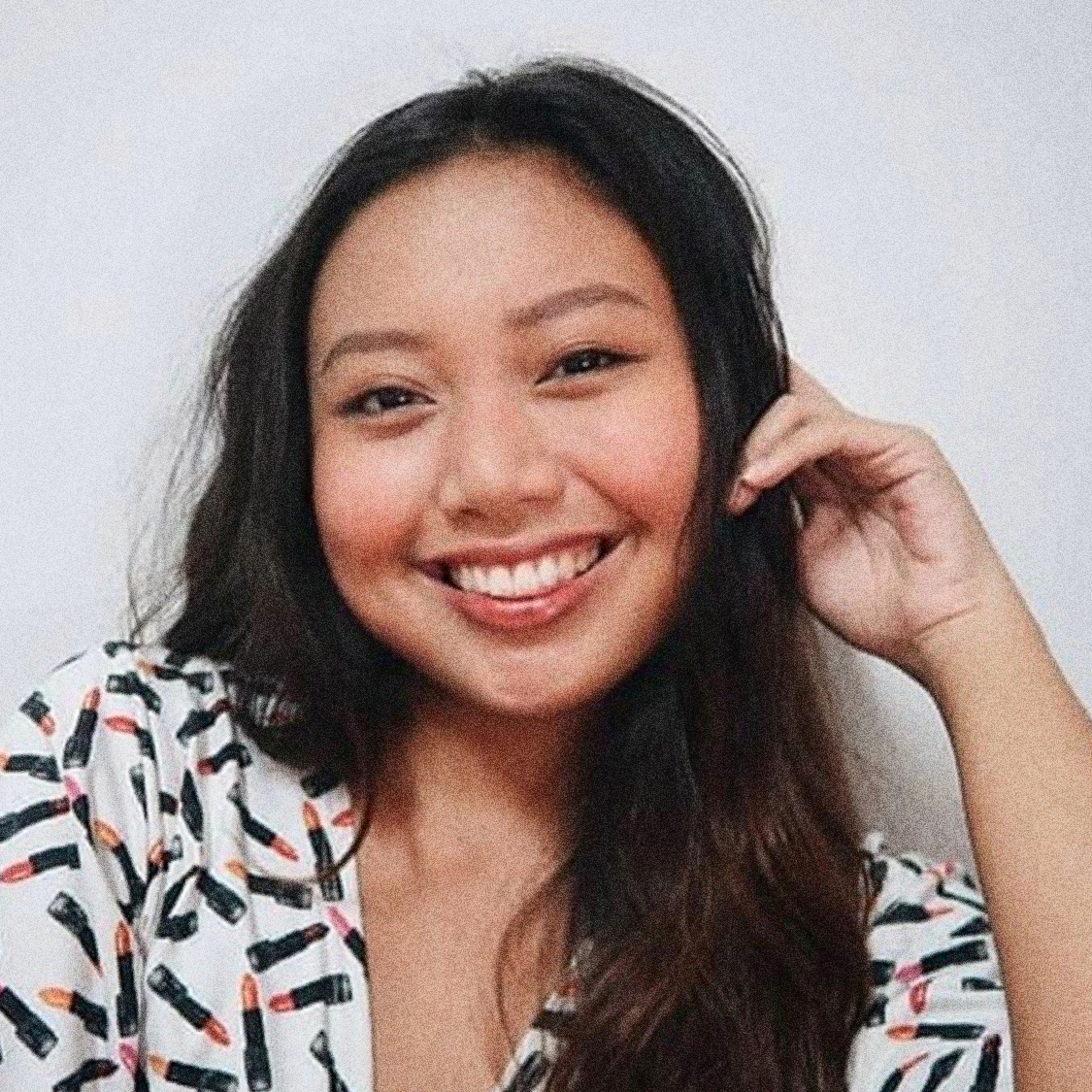 A selfie of Maya smiling, her hair and makeup done